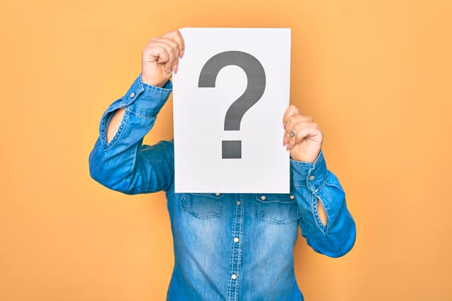 Vera-Birkenbihl-Online-Sprachkurs-ohne-Sprachkenntnisse-Klarsicht-Verlag Eine Person haelt ein Schild mit einem großen Fragezeichen darauf vor das Gesicht.